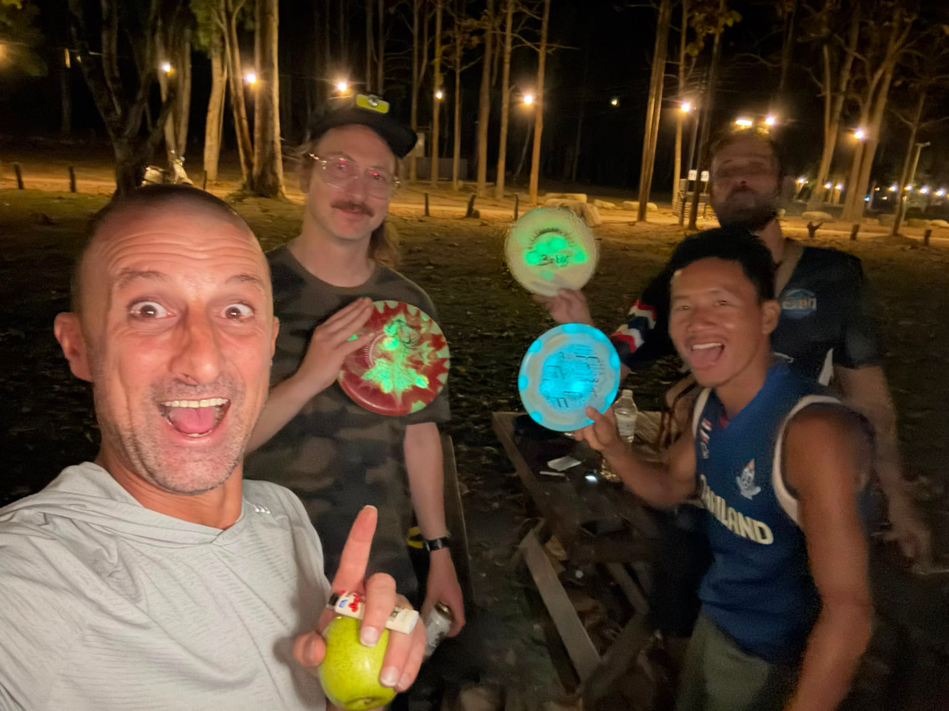 Players holding glowing discs during night glow golf at Rock n' River